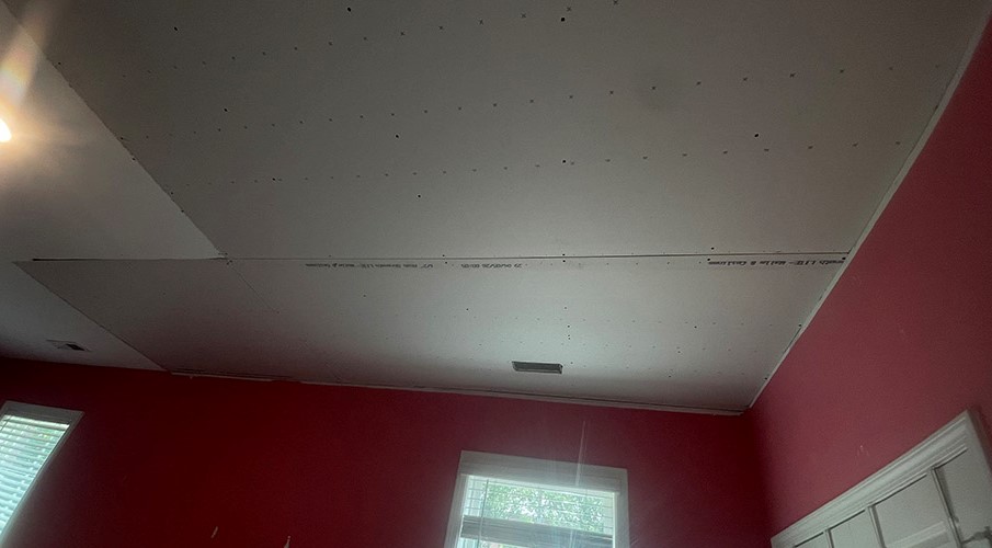 Drywall ceiling panels installed around attic access hatch
